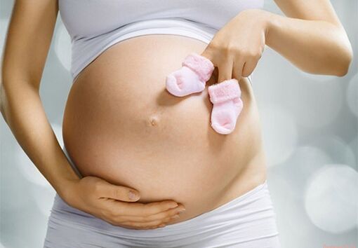 Μια έγκυος γυναίκα δίνει θηλώματα στο μωρό της